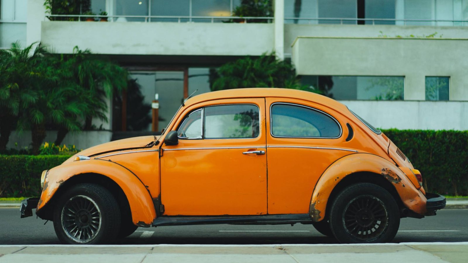 yellow VW beetle car outside white building 